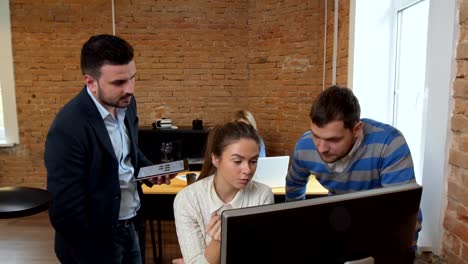 Creative-business-team-meeting-in-modern-start-up-office-female-team-leader-pointing-at-screen