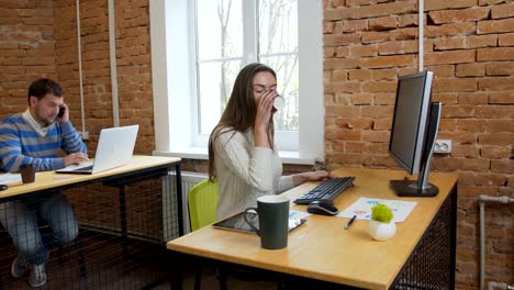 Closeup.-Porträt-einer-schönen-jungen-Frau-und-Mann,-die-auf-dem-Computer-im-Büro-arbeiten.