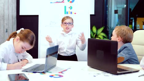 Beautiful-young-businesswoman-girl-child-during-a-meeting-at-the-office-discussing-a-business-plan-with-colleagues