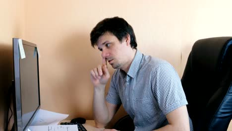 Young-man-picks-his-nose-working-at-the-computer.