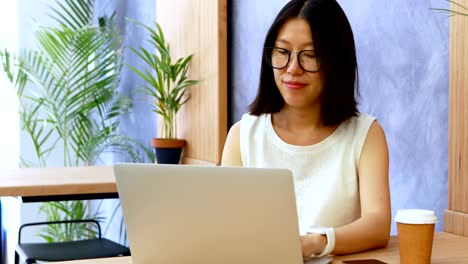 Female-executive-checking-time-on-smartwatch-while-working-at-desk-4k