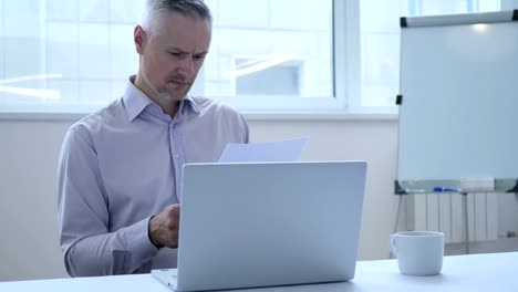 Middle-Aged-Businessman-Working-on-Documents-,-Paperwork