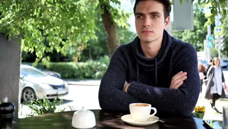 Young-Man-Sitting-in-Cafe-Terrace