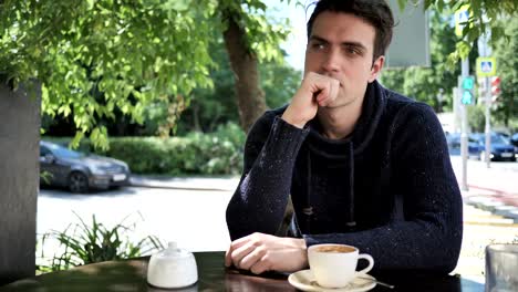 Thinking-Young-Man-Sitting-in-Cafe-Terrace