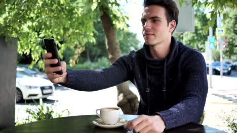 Junge-Menschen-nehmen-Selfie-am-Telefon-beim-Sitzen-im-Cafe-Terrasse