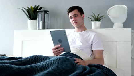 Unterlegene-aufgeregt-Mann-mit-Tablet-im-Bett