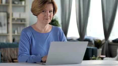 Old-Senior-Woman-Pointing-Toward-Camera-at-Work