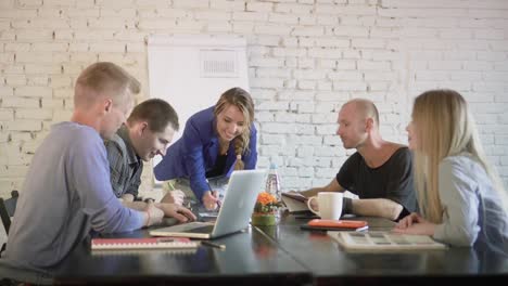 Businesswoman-presenting-to-the-team-taking-notes-in-the-boardroom.-Female-manager-in-the-office-is-talking-to-employees-about-business-plan