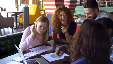 concepto-de-negocio,-puesta-en-marcha-y-personas---equipo-creativo-feliz-con-computadoras-y-carpeta-discutiendo-proyecto-de-loft-espacio-compartido.