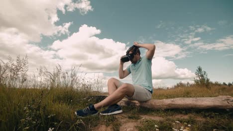 Man-in-Virtual-Reality-Headset-sitting-at-nature.-Male-watching-video-360