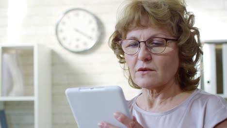 Mature-Businesswoman-Working-on-Tablet-in-Office