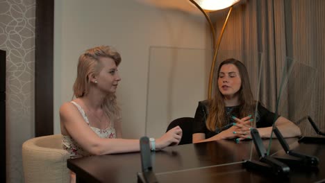 Two-ladies-look-at-two-transparent-displays-set-and-discussing