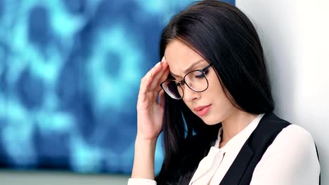 Portrait-attractive-businesswoman-in-glasses-having-headache-on-hitech-exhibition