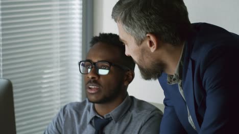 Male-Colleagues-Discussing-Work-Results