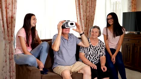 Senior-man-in-virtual-reality-headset-or-3d-glasses-having-fun-with-family