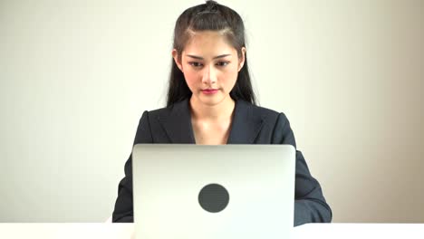 Mujer-de-negocios-escribiendo-en-la-laptop.-Mujer-de-negocios-asiática-hermosa-joven-en-juego-escribiendo-en-la-computadora-portátil-frente-a-cámara.