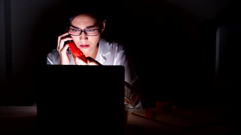 Beautiful-asian-woman-working-on-her-computer-with-3d-printer-in-background,-complaining-to-supplier-on-phone.-Modern-start-up-global-business-concept.