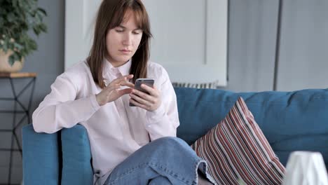 Young-Girl-Using-Smartphone,-Browsing-Internet-at-Home