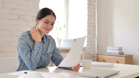 Young-Girl-Reacting-to-Successful-Contract,-Reading-Documents