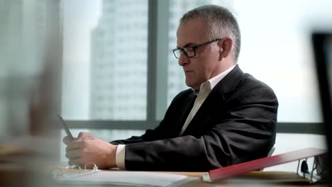 Business-Man-In-Office-Texting-Message-On-Smartphone-During-Break