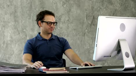 Bored-young-man-at-the-desk-in-front-of-computer