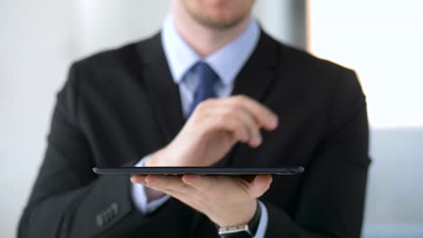 businessman-working-with-tablet-pc-and-something-imaginary