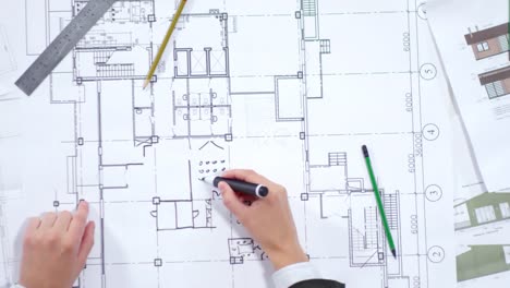 Hands-of-Professional-Architect-Drawing-Floor-Plan