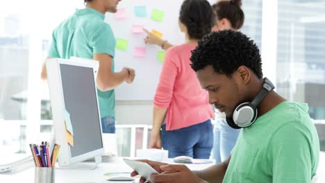 Attentively-working-creative-designer-using-his-tablet