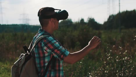 Junge-mit-Rucksack-auf-Straße-zu-virtual-Reality-Brille-betrachten.-Gerät.-Sommer