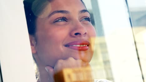 Smiling-woman-looking-out-office-window