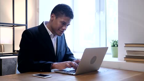 Black-Man-Smiling--toward-Camera,-Working-in-Office