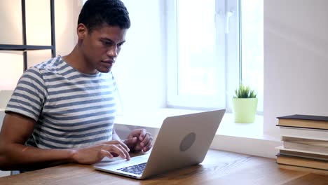 Junge-schwarze-Mann-arbeitet-auf-Laptop