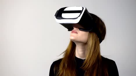 Casual-young-woman-wearing-virtual-reality-goggles-moving-hand
