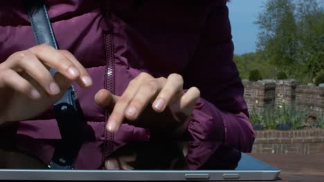 Eine-junge-Dame-mit-einem-Tablet-im-Park