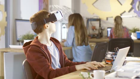 In-a-Computer-Science-Class-Boy-Wearing-Virtual-Reality-Headset-Works-on-a-Programing-Project.