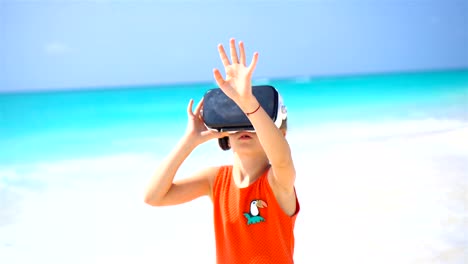 Gafas-niño-niña-linda-usando-realidad-virtual-VR.-Adorable-chica-mire-las-gafas-virtuales-en-Playa-Blanca