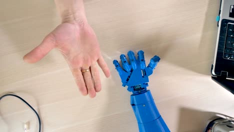 Mano-robótica-repitiendo-movimientos-de-mano-derecha-del-hombre.