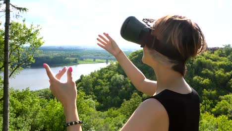 Young-woman-uses-head-mounted-display-in-the-park.-Playing-game-using-VR-helmet-for-smart-phones