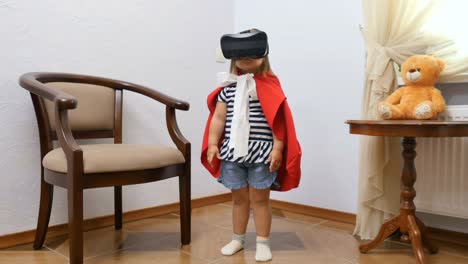 Niña-linda-en-capa-roja-utiliza-unas-gafas-de-realidad-virtual