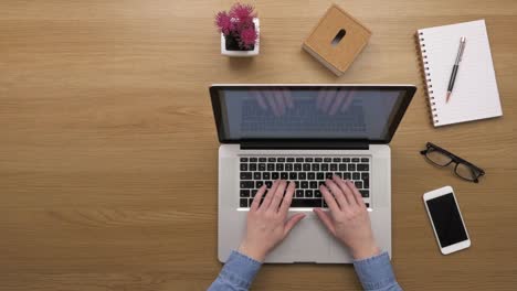 Overhead-Top-View-Footage-Of-woman-Using-Laptop-At-Wooden-Desk