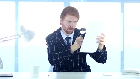 Man-Reading-Douments-with-Magnifier-at-Work,-Red-Hairs