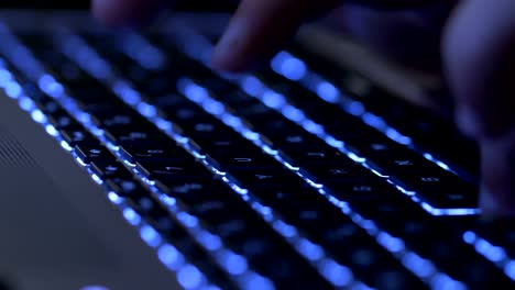 Typing-on-the-illuminated-laptop-at-night