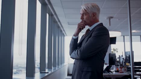 Businessman-looking-outside-the-window-and-thinking