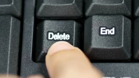 Close-up-of-human-finger-pushing-an-delete-button-on-the-computer-keyboard