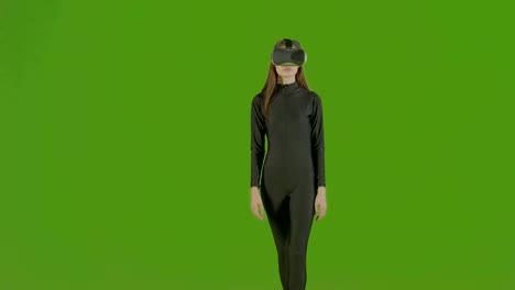 Attraktives-Mädchen-junge-Mode-Modell-tragen-ein-VR-Kopfhörer-im-Greenscreen-Studio-gedreht.-Interaktive-futuristische-Geste.-Mittlere-s