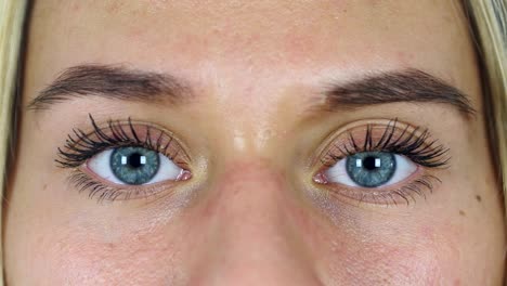 Close-Up-of-Young-Female-Blinking-B-White-Background