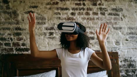 Lockige-afroamerikanische-Frau-Erfahrungen-mit-VR-360-Kopfhörer-Brille-der-virtuellen-Realität-zu-Hause