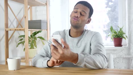 Smartphone-Video-Chat-von-jungen-afroamerikanischen-Mann-im-Büro