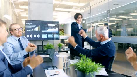 Asian-Businessman-Gives-Report/-Presentation-to-Her-Business-Partners-Everybody-Cheer-and-Applaud-and-Give-High-Five-Approving-His-Project.