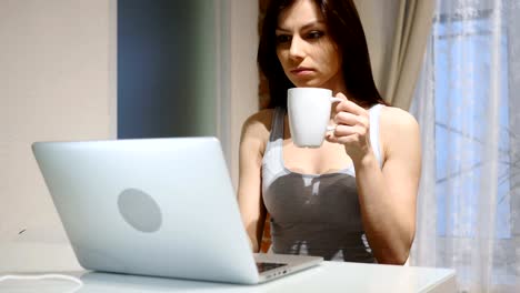 Portrait-of-Young-Woman-Drinking-Coffee-and-Working-on-Laptop